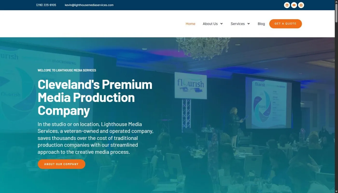 The Lighthouse Media Services homepage: a teal-tinted photo of a ballroom conference with a presenter on stage behind the headline Cleveland's Premium Media Production Company and an orange About Our Company button